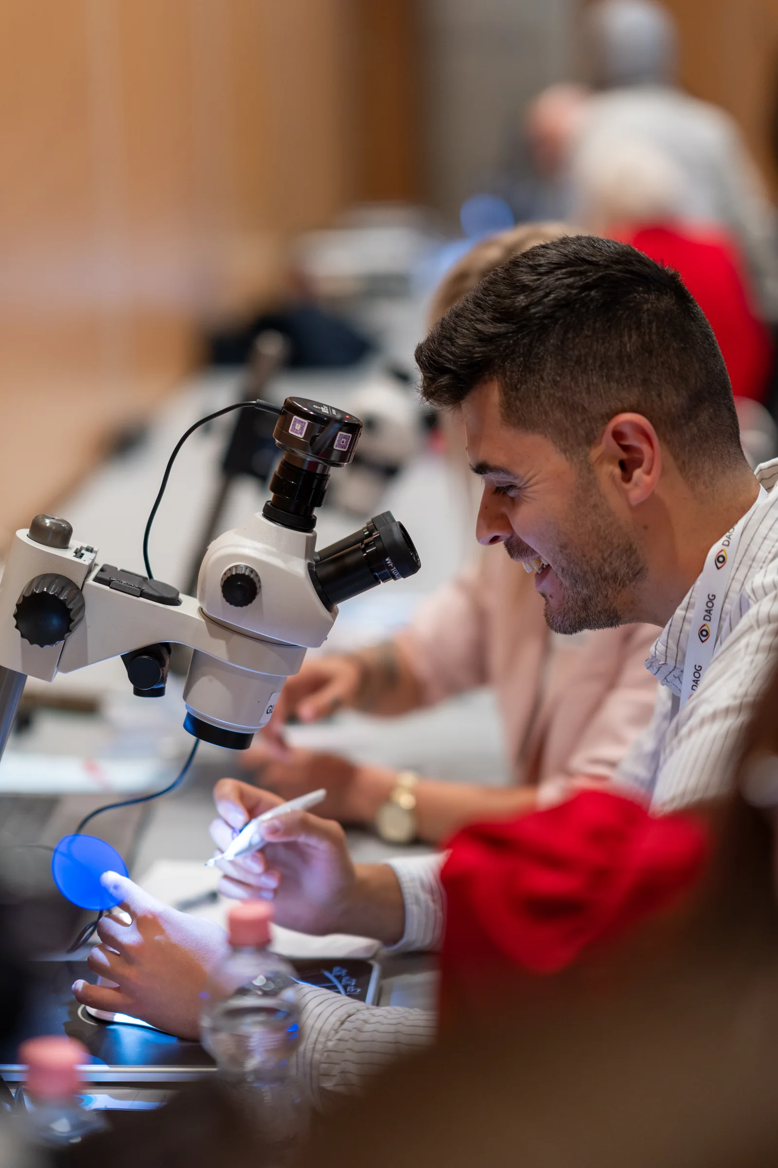 Lächelnder Teilnehmer übt am Stereomikroskop